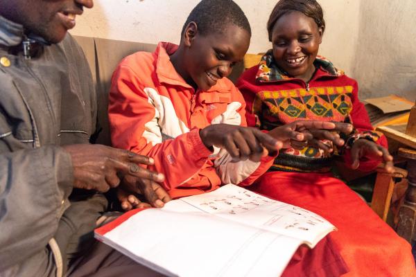 A pupil learns Kenyan Sign Language from a textbook at Kapsabet School for the Deaf