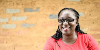 Volunteer Monica Atim smiles as she sits outside