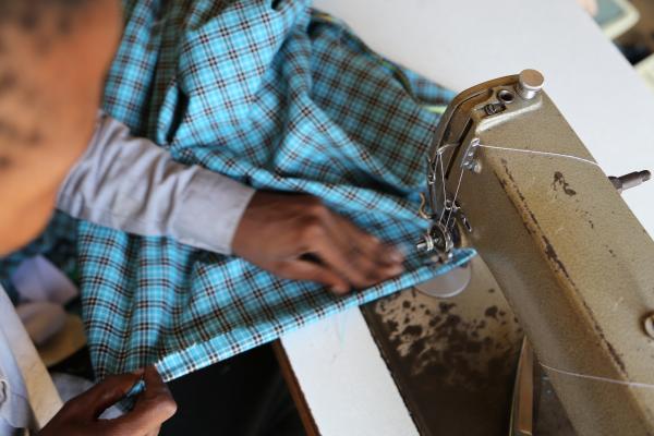 Close up of a tailor using a sewing machine