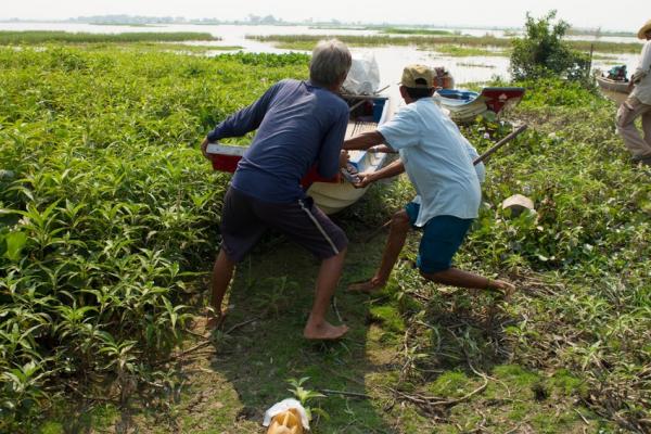 Fishermen pull in fishing boat by the Tonle Sap lake, Cambodia. 