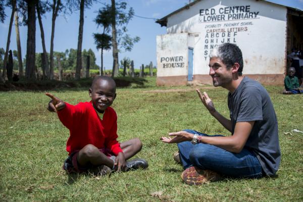 ICS volunteer Asher sits next to a deaf primary school student