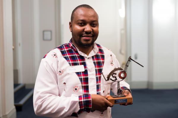 Harrison with his trophy at the VSO Volunteer Impact Awards