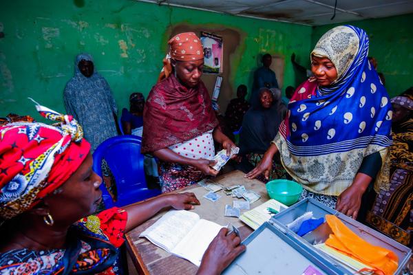 Aisha Usman stands with other co-operative members as they meet and pay off loans