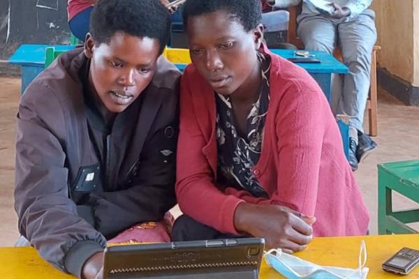 Teachers watch play-based learning models on a tablet