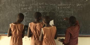 Girls at Moroto Demonstration Primary School learn on a blackboard