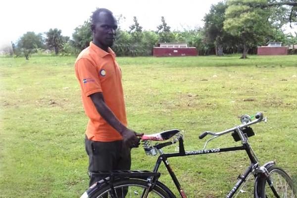 Volunteer Wangdic Justine uses a bicycle provided by VSO to access isolated households 