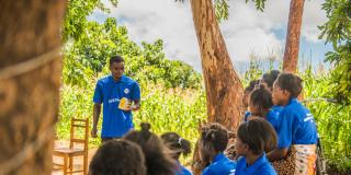 community volunteer using a Talking Book to deliver a lesson to the students.